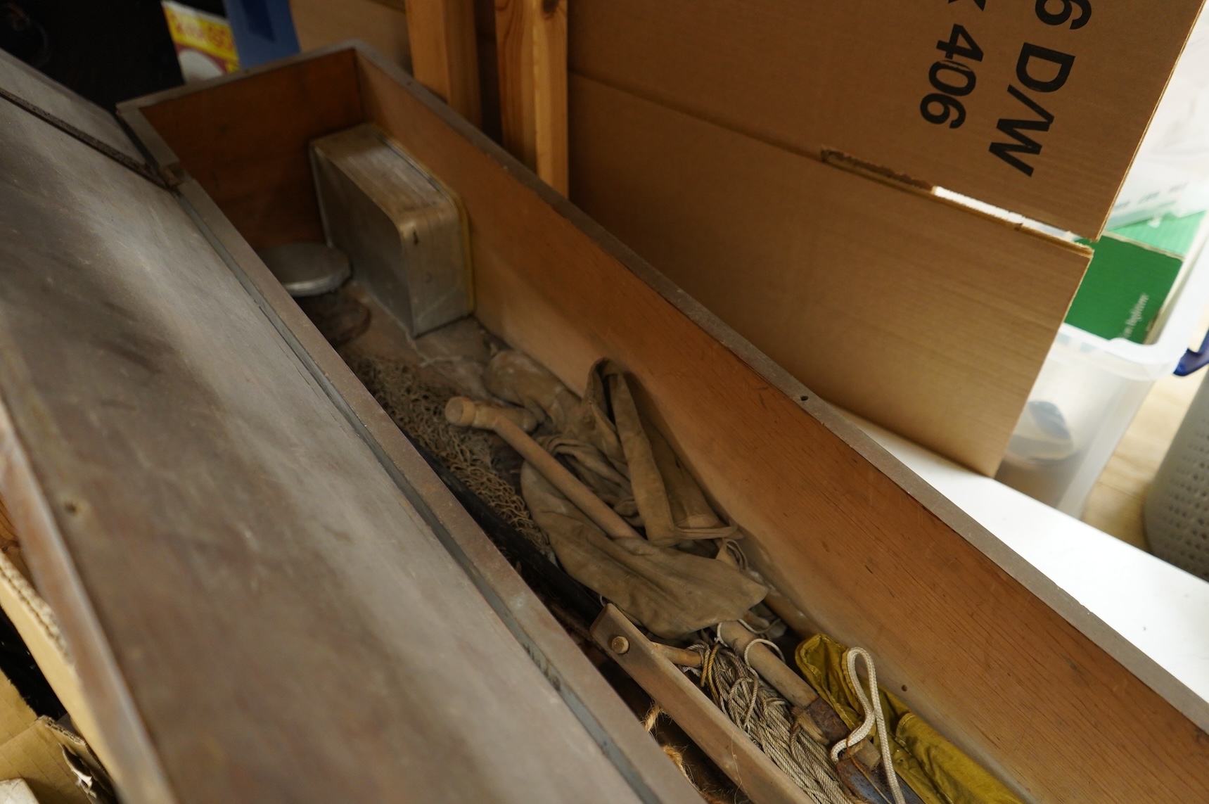 A collection of split cane fishing rods, reels, landing net etc contained in a large wooden box